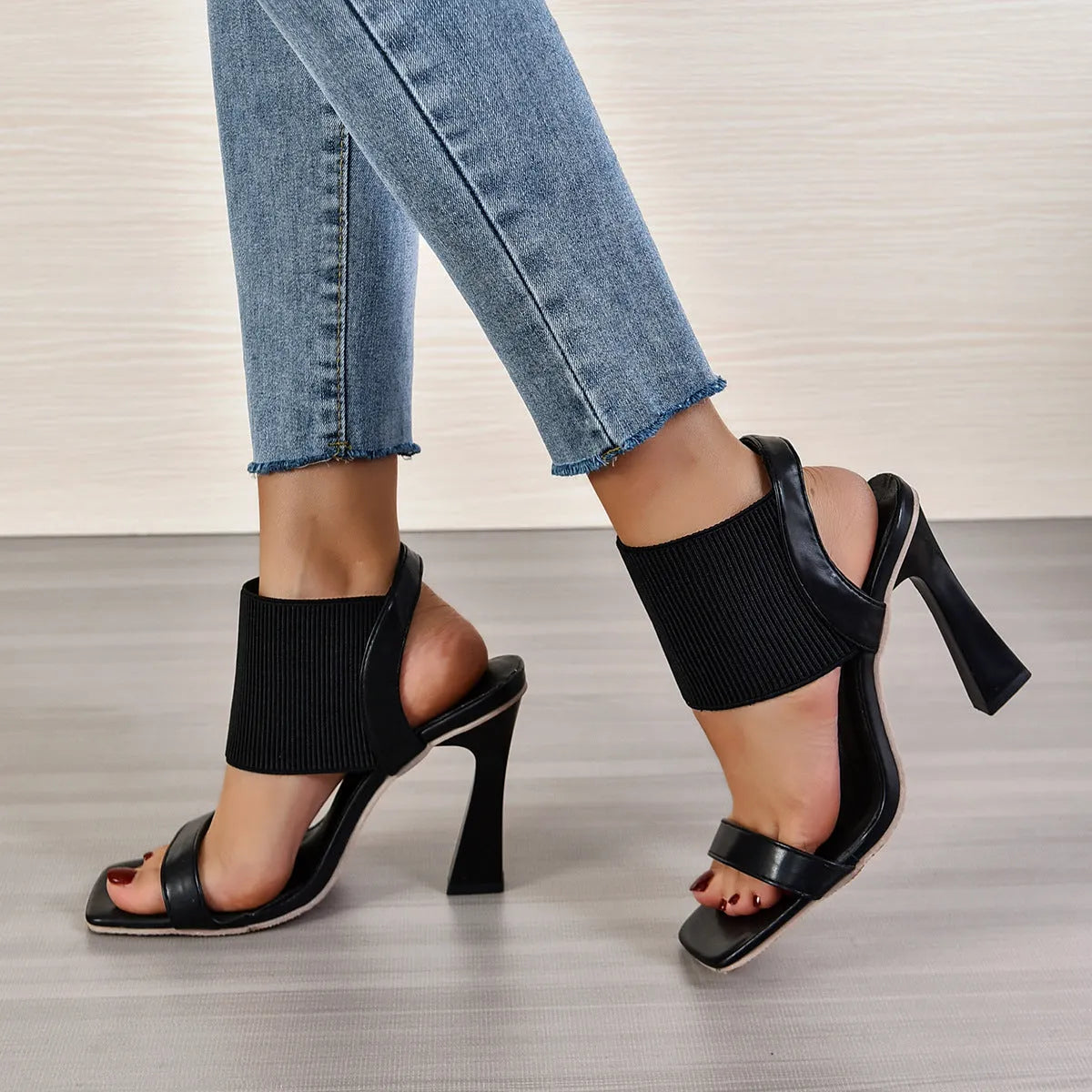 Black high heel sandals for women with criss-cross elastic straps and a rubber sole.