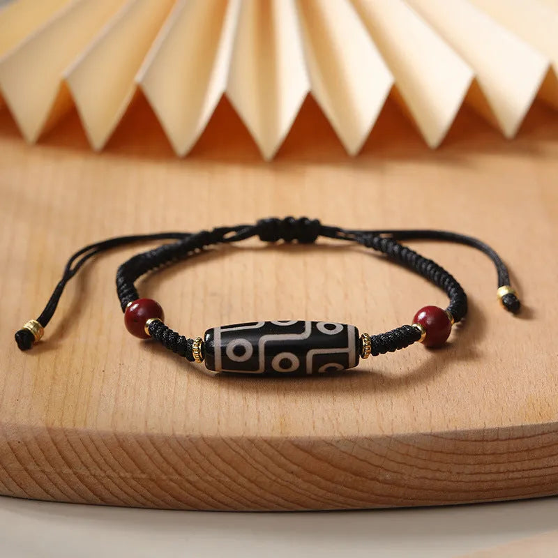 Men's adjustable agate dzi bead bracelet with traditional symbols on a shrinkable band.