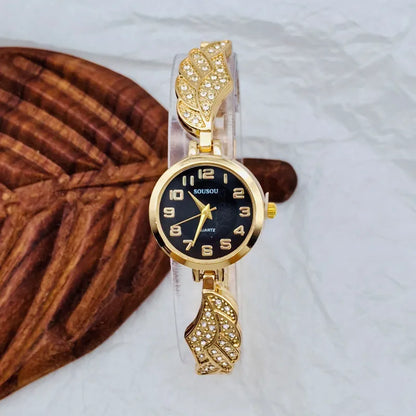 Round stainless steel women's watch on wrist showing gold surface colour and vachette clasp buckle.