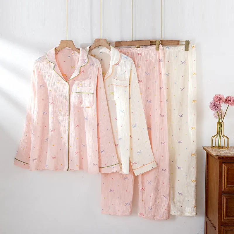 Women's pink cotton long sleeve pajama set with trousers on a hanger.