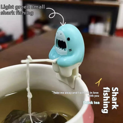 Shark-shaped tea infuser hanging on cup edge, made from food-grade silicone