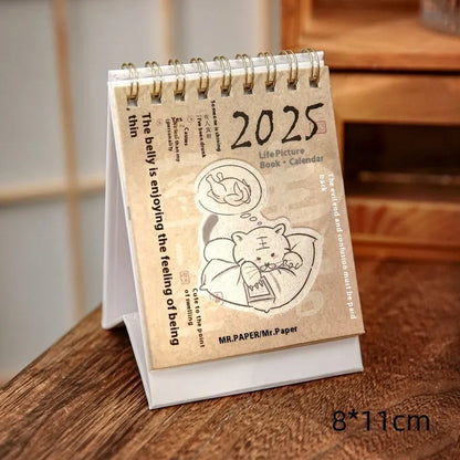 2025 mini desk calendar showing one of four designs: Coffee Time, Awake Time, Corner Perching, or Afternoon Lazy.