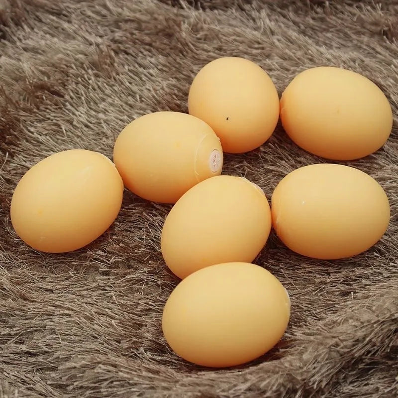 Pink rubber simulation egg dog toy with a textured surface for chewing.