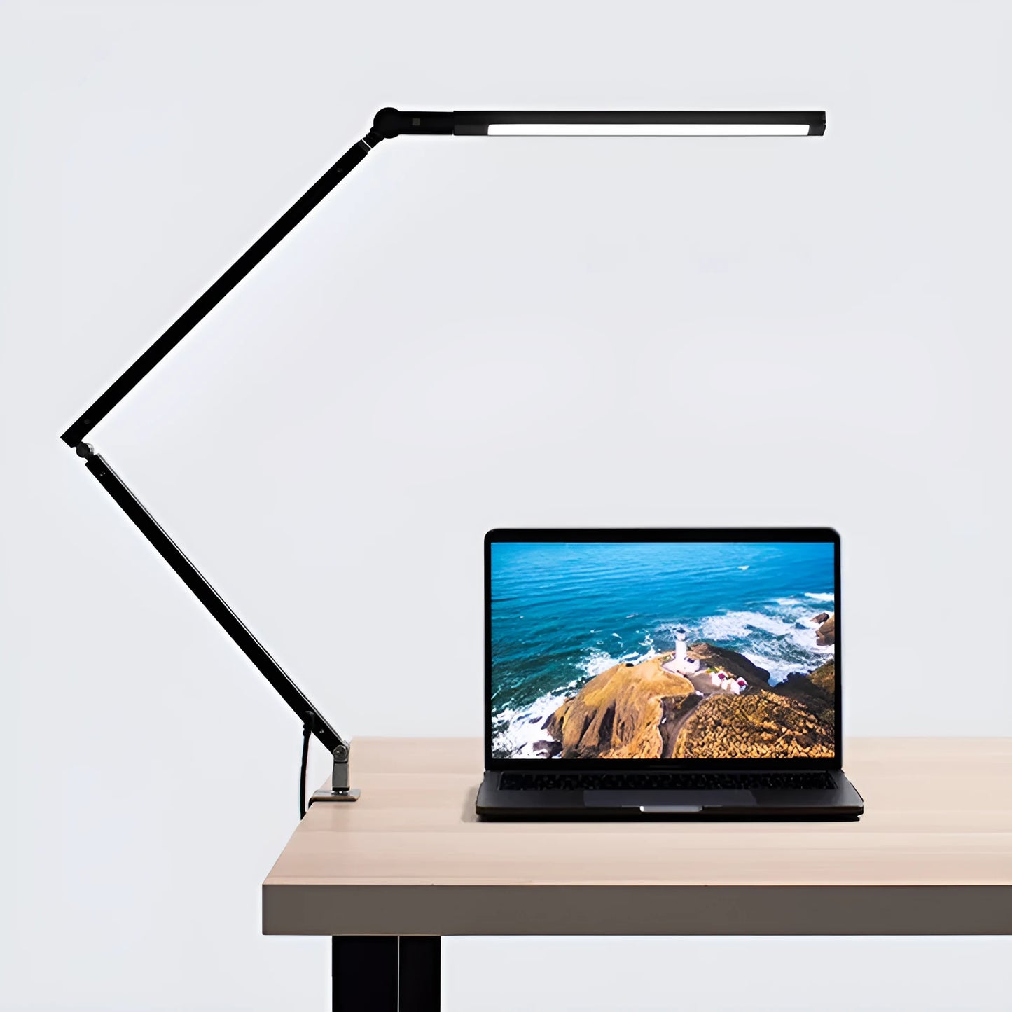Clip-on adjustable arm LED desk lamp in black mounted on a desk edge with remote control.