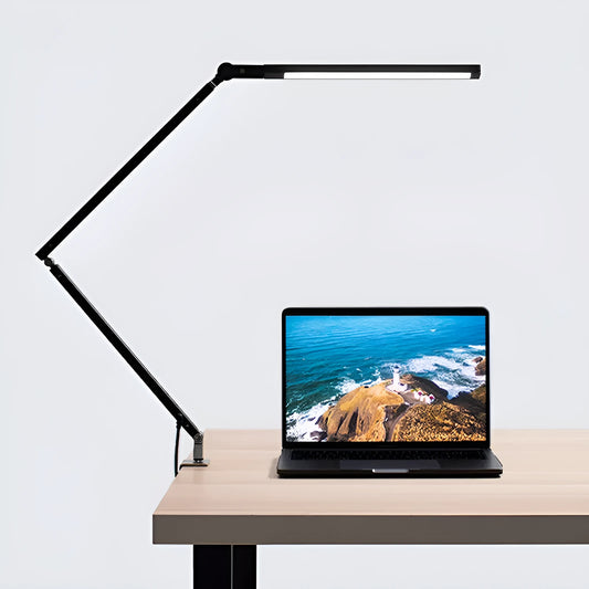 Clip-on adjustable arm LED desk lamp in black mounted on a desk edge with remote control.