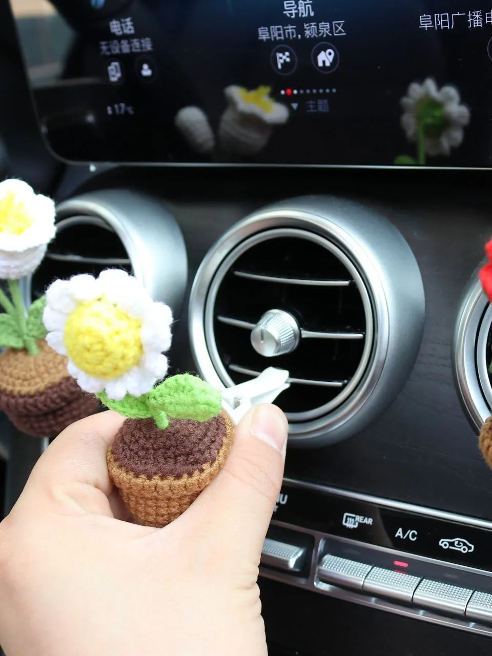Creative wool potted plant car air vent clip aromatherapy pendant on a car vent.