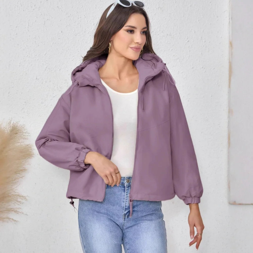 Women's grey hooded shell jacket with loose fit and long sleeves on hanger