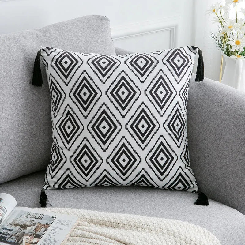 Bohemian style decorative pillowcase in light grey colour on a sofa.
