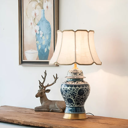 Traditional blue and white Chinese ceramic table lamp with a cloth shade on a bedside table.