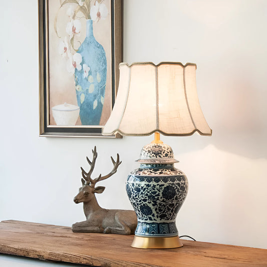 Traditional blue and white Chinese ceramic table lamp with a cloth shade on a bedside table.