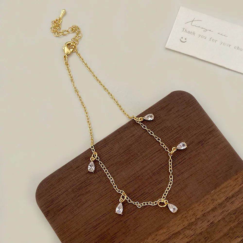 Women's zircon jewellery set showing geometric meteor shower design on necklace, earrings, and anklet