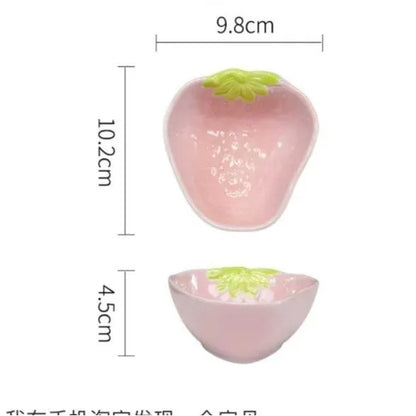 Porcelain dinnerware set with strawberry pattern, showing plates, bowls, and a twist spoon in various sizes