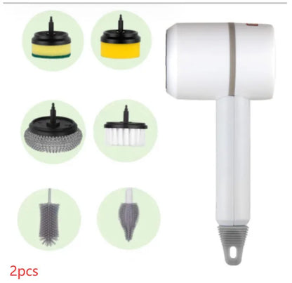 Green electric cleaning brush with scouring pad and brush heads on a kitchen worktop.