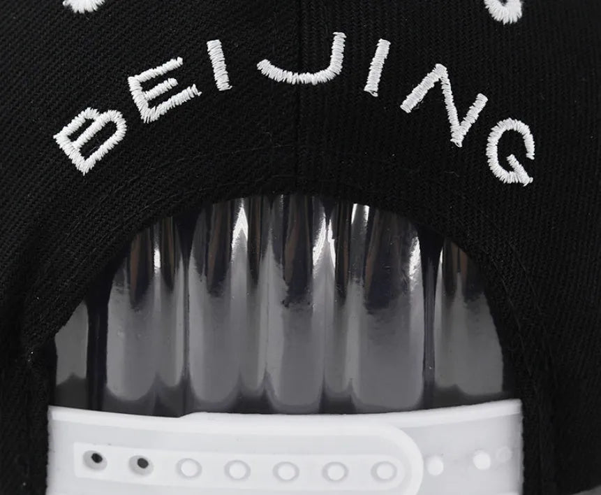 Cotton baseball hat with letter embroidery showing dome crown and adjustable strap in black and white colour options