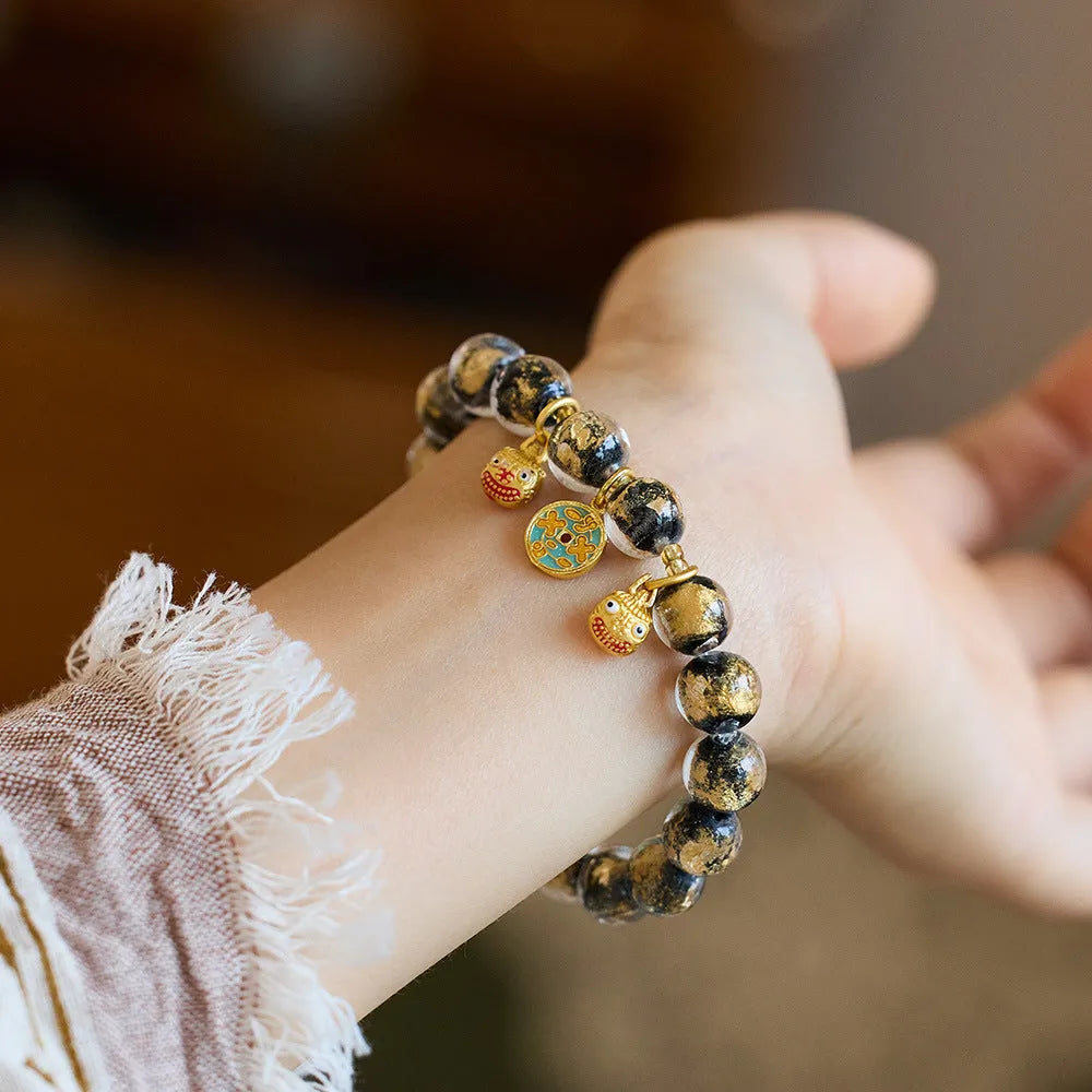 Handmade national style bracelet with coloured glaze swallowing gold beast charm on beaded band.