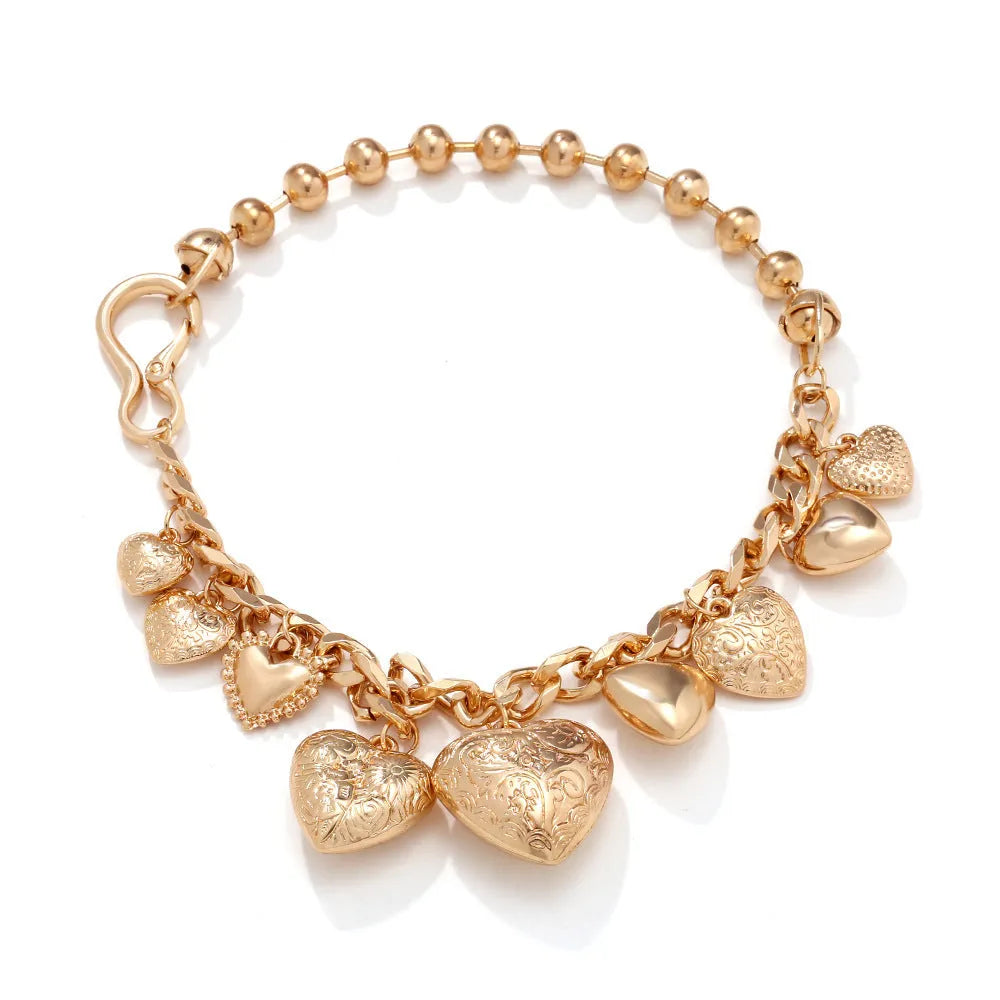 Gold carved heart pendant necklace on adjustable chain, showing exaggerated shape and textured details