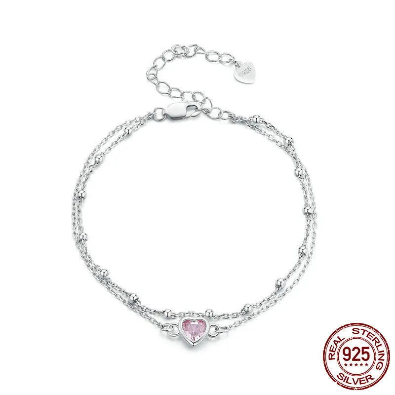 Close-up of a sweet girlish style 925 sterling silver bracelet with a small heart-shaped pendant on an adjustable chain.