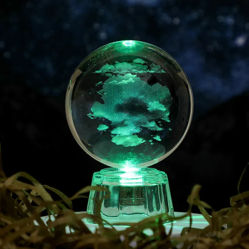 Transparent crystal ball ornament with inner carving of clouds, shown on a wooden table.