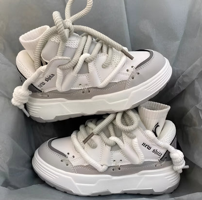 Women's grey chunky platform sneakers with white thick rubber sole and lace-up front.