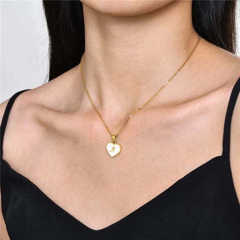 Gold-plated clavicle necklace with a white shell heart pendant, personalised with a letter from A to Z.