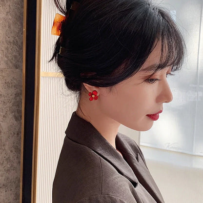 Silver-tone earrings with delicate red petal design, perfect for adding a touch of Korean-inspired elegance to any outfit.