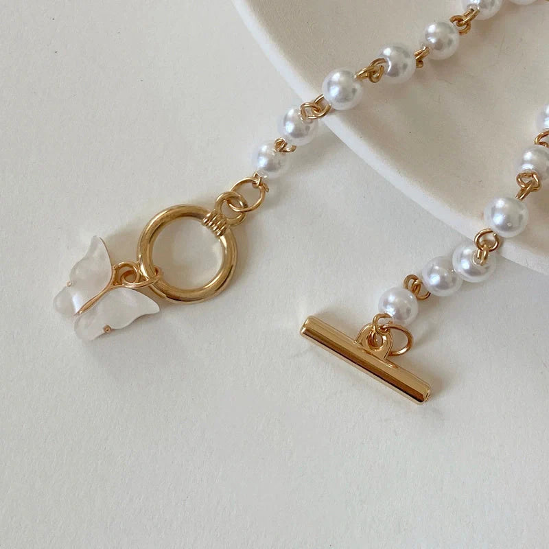 Gold charm bracelet with pearl and butterfly design for women