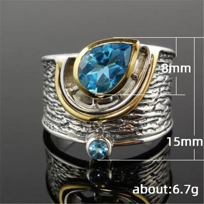 Drop-shaped women's ring with inlaid blue zircon stones on a model's hand, showing Chinese style details.