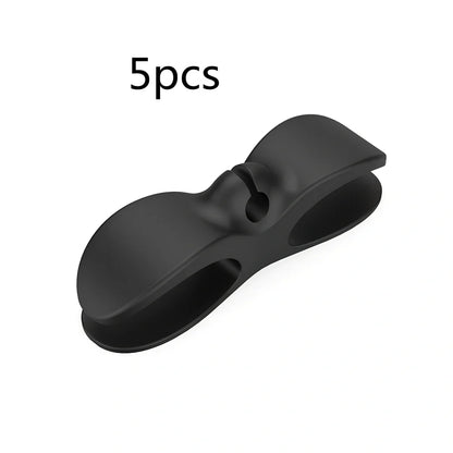 Black TPU cable organizer clips winding appliance cords on kitchen counter, 5cm size, non-marking adhesive for tidy management