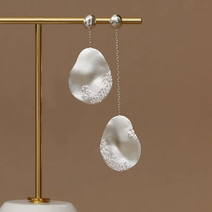 Asymmetric floral drop earrings with gold plating and zircon stone accents in silver colour
