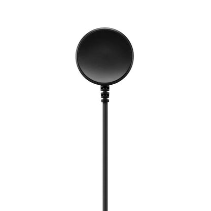 Black plastic USB wireless charging dock for smartwatches on a flat surface.