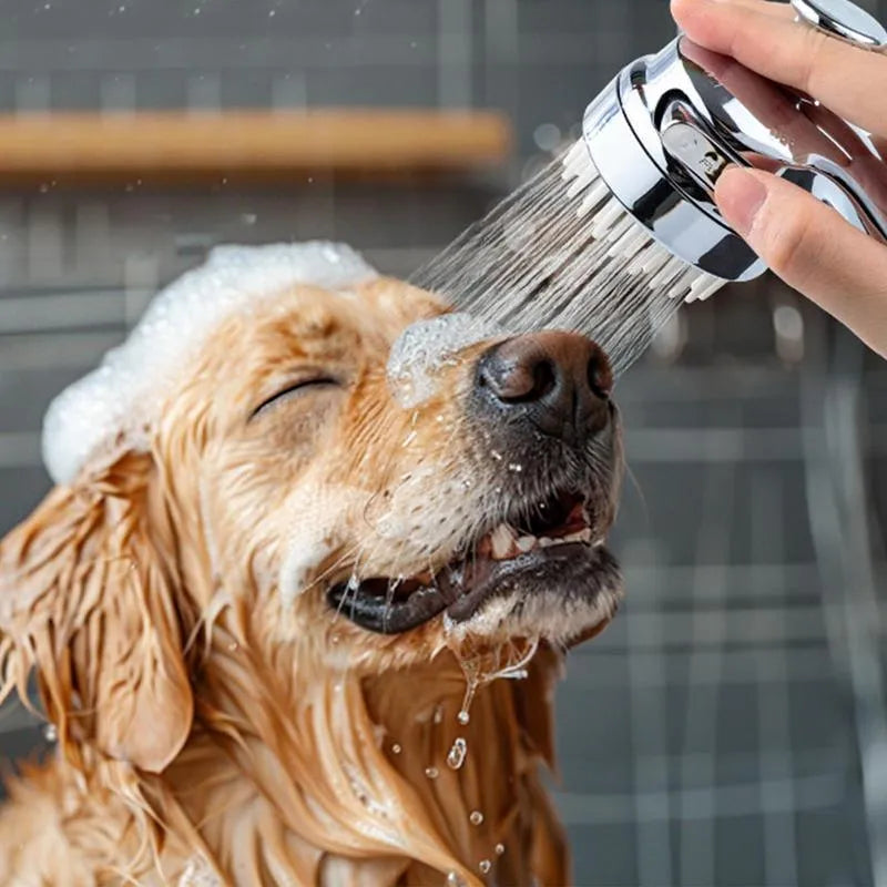 Silver dog shower attachment with silicone comb teeth and ergonomic grip for pet bathing.