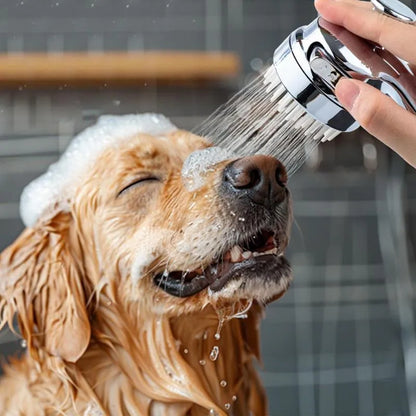 Silver dog shower attachment with silicone comb teeth and ergonomic grip for pet bathing.