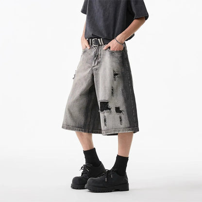 Grey women's denim shorts with distressed holes and water washed finish, loose cropped fit