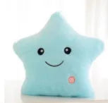 Colourful glowing five-pointed star plush pillow on a dark background.
