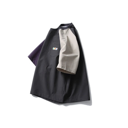 Dark grey loose fit men's t-shirt with contrast colour raglan sleeves on a hanger.