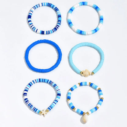 Six handmade polymer clay bracelets with geometric shell designs in bohemian blue colour