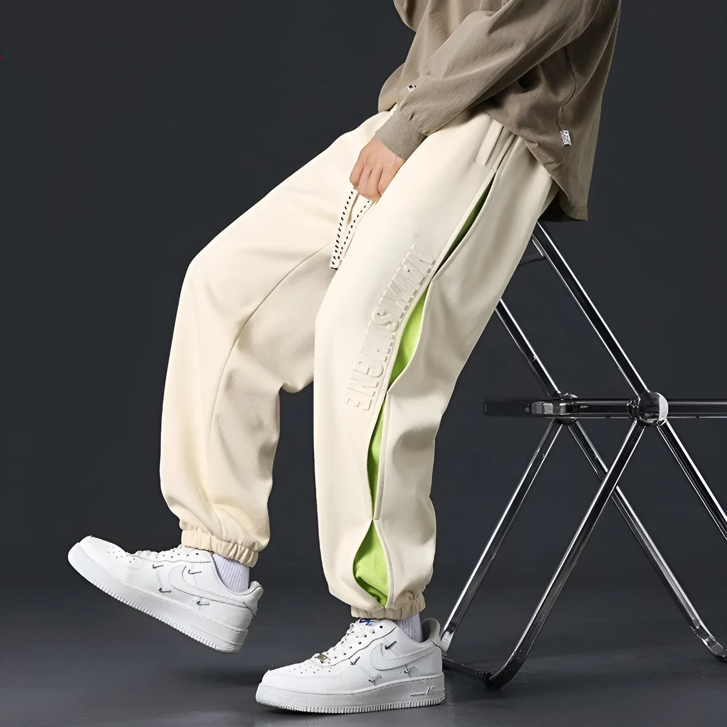 Men's ankle banded trousers in micro-elastic cotton with collage stitching details, showing loose fit and tapered leg