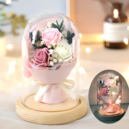 Soap flower bouquet in glass display cover with red roses visible through clear 11.2cm dome