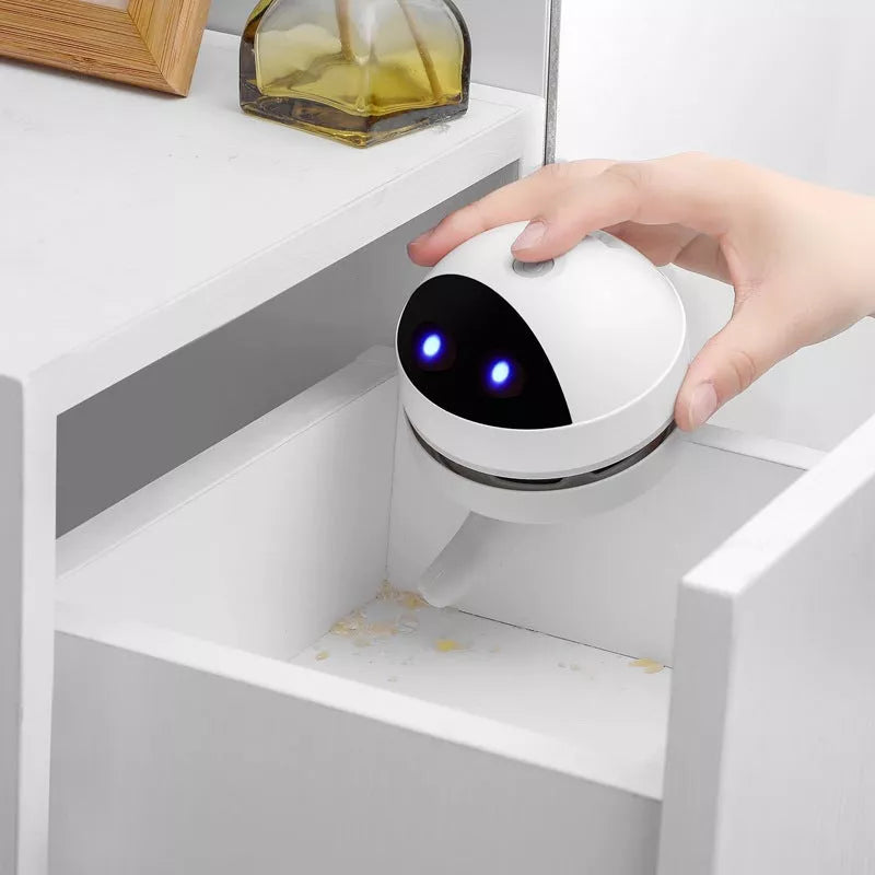 Compact USB charging wireless mini portable robot desktop vacuum cleaner on a desk