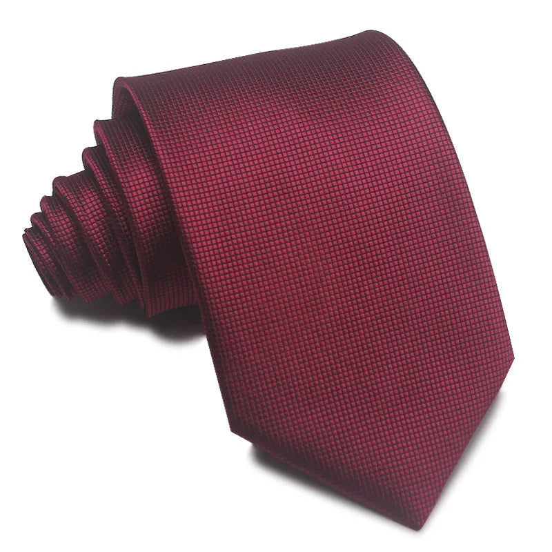 Close-up of a red and black striped jacquard weave tie with an arrow tip, showing texture.
