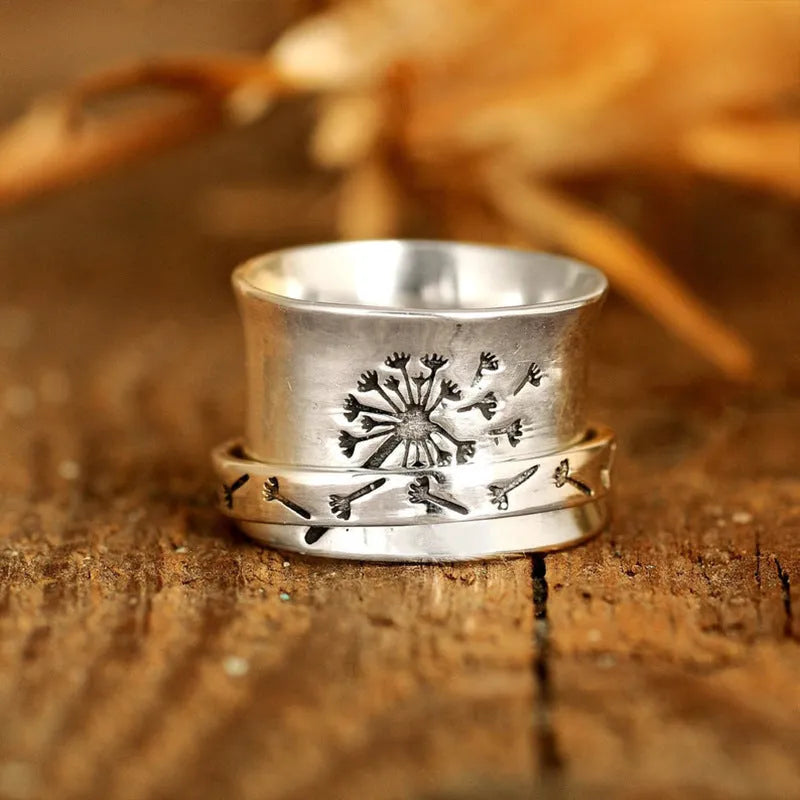 Silver-coloured rotating flower ring on finger showing adjustable floral element