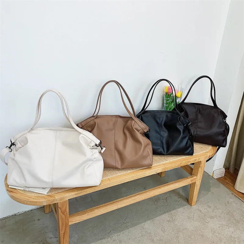 Large soft black PU messenger bag with long shoulder strap and front car suture detailing