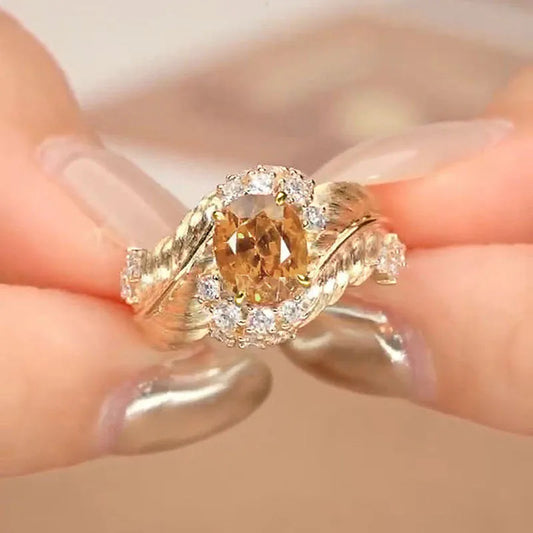 Gold-coloured embossed feather ring with inlaid yellow zircon stone, showing detailed texture and geometric shape