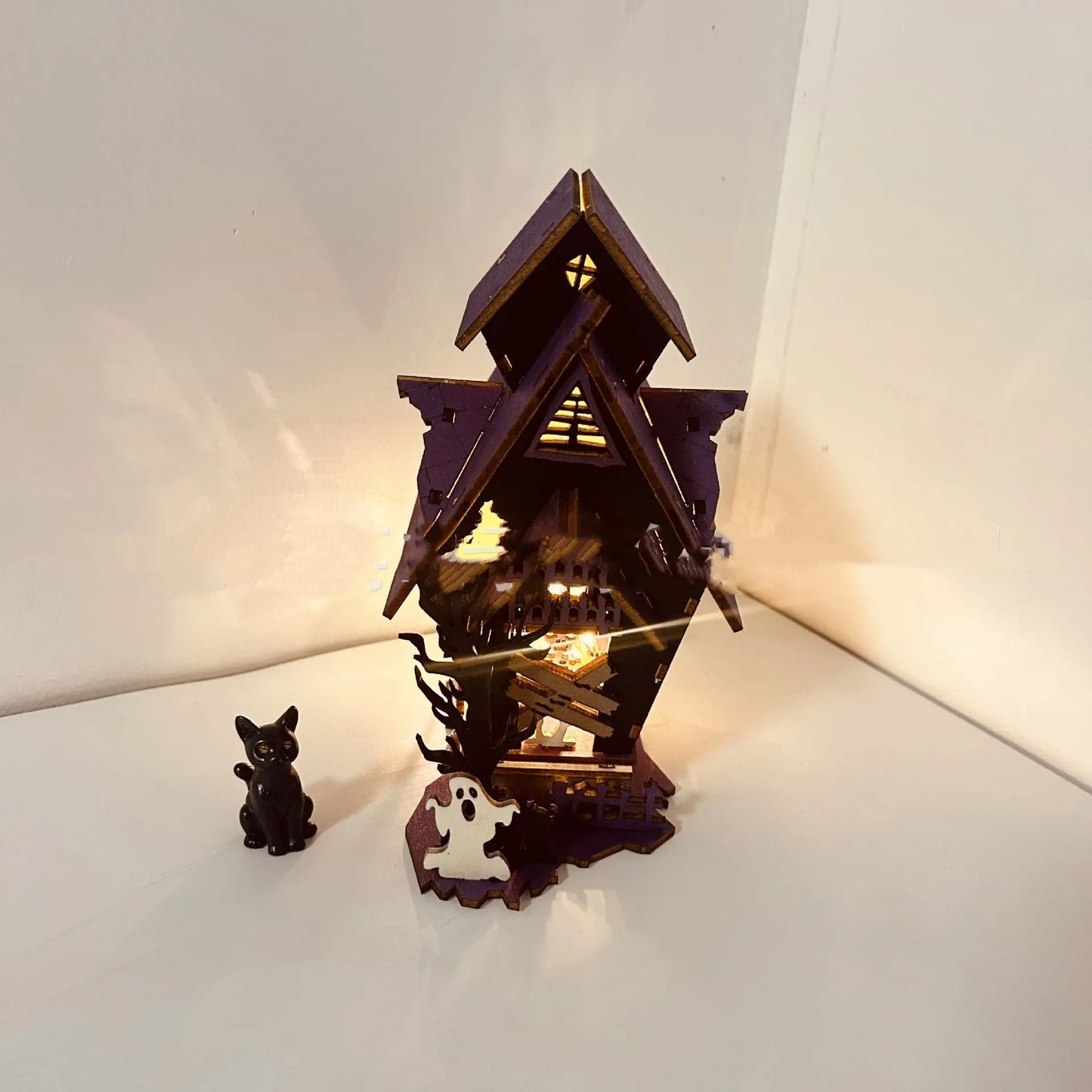 Wooden haunted house table decoration measuring 14x10.5x19cm with luminous finish and candlestick holder function