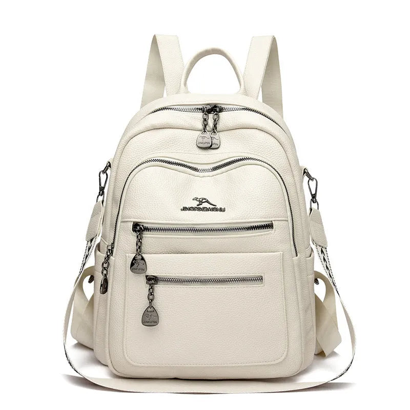 Genuine leather multi-functional commuting backpack with flap pocket, polyester lining, and metal letter patchwork details in black.