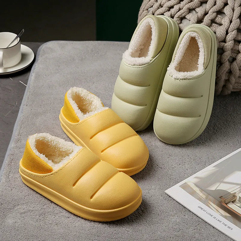 Yellow women's winter slippers with waterproof EVA sole and plush lining on a wooden floor.