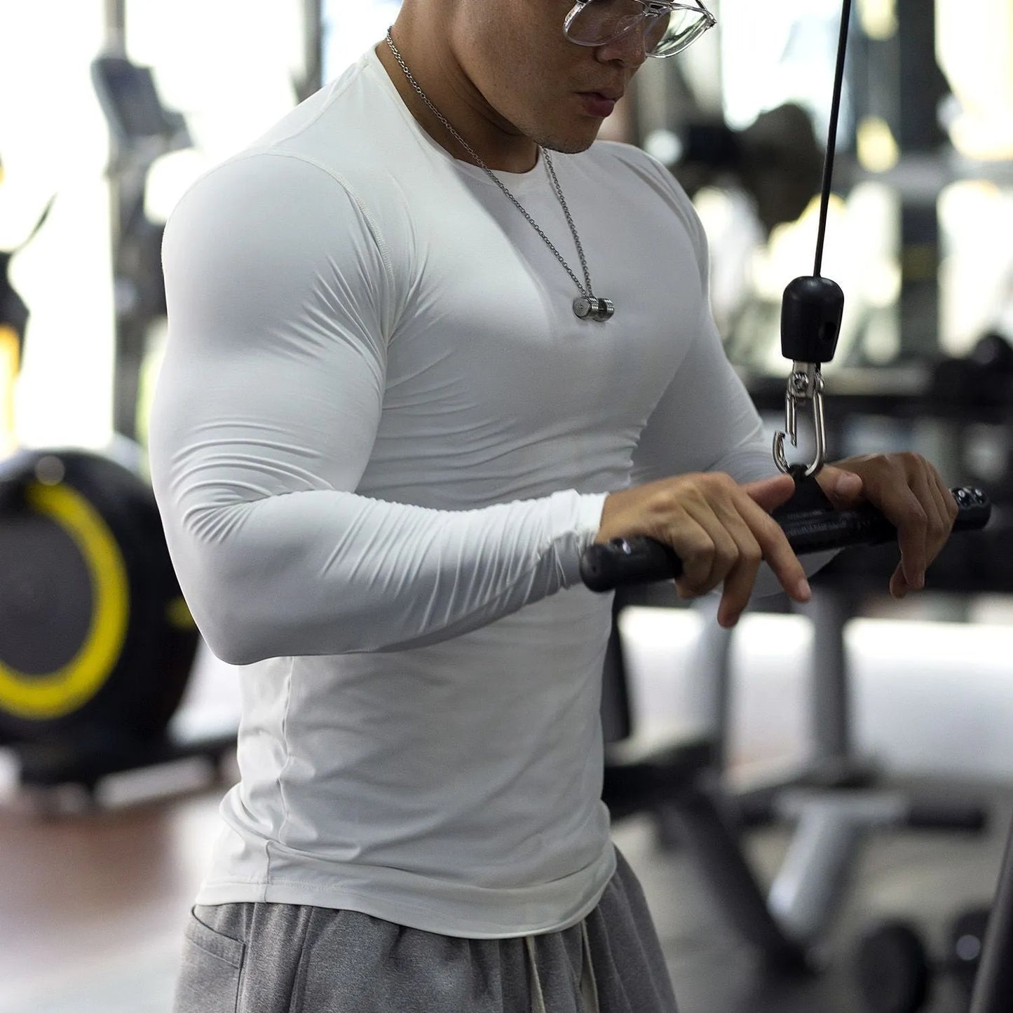 Man wearing black long sleeve slim fit fitness tights for running or gym workout.