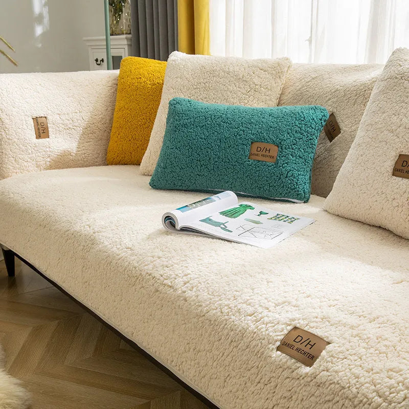 Beige lamb wool plush sofa cover with anti-slip backing on a grey fabric sofa.