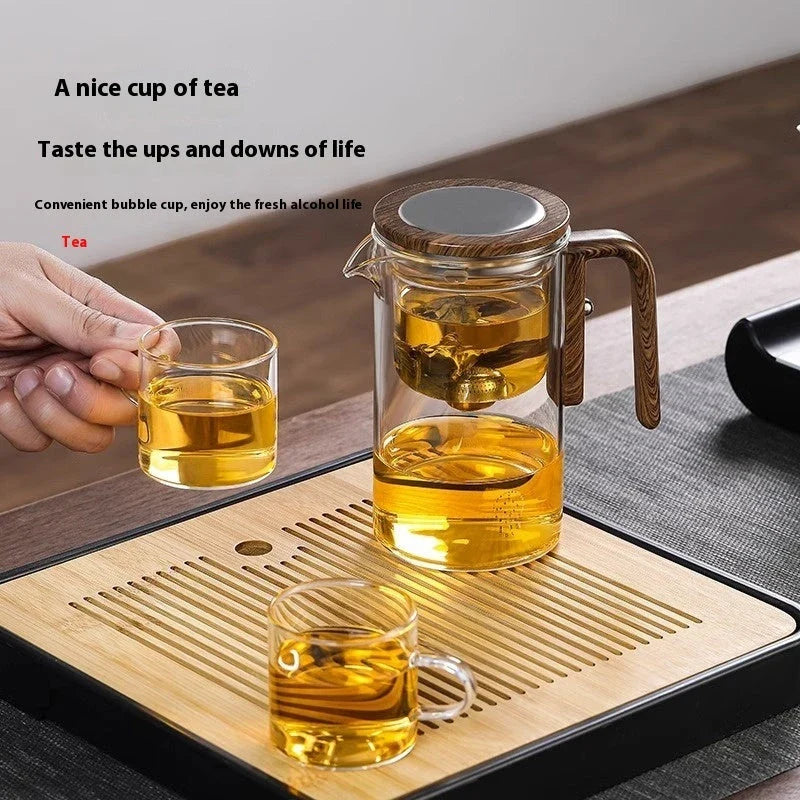 Elegant glass tea infuser pot with magnetic separation technology, wooden handle, and precise pouring spout
