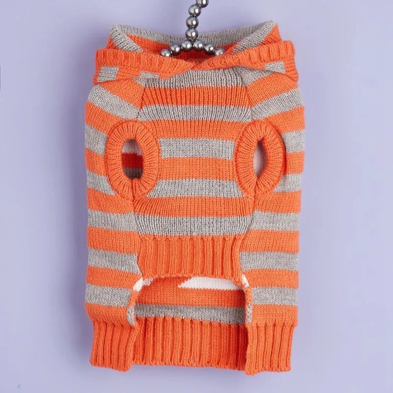Orange Halloween pet sweater with knitted stripes, fur ball accents, and hood for cats or dogs